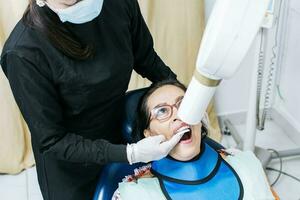 hembra dentista haciendo dental radiografía, hembra dentista haciendo radiografía a paciente, hembra dentista haciendo dental radiografía, dental radiografía concepto foto