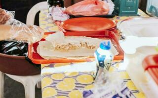 Homemade Nicaraguan quesillo, traditional large quesillo food. Hands making a Nicaraguan quesillo. Close up of hands making a traditional quesillo with pickled onion. photo