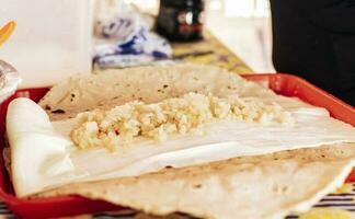 Traditional Quesillo with pickled onion, Preparation of Traditional Nicaraguan Quesillo. Person making delicious Nicaraguan cheese. Hands preparing the traditional Nicaraguan Quesillo photo