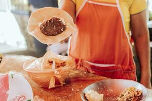 Hands of a vendor showing the process of elaboration of the traditional pupusa. Elaboration of traditional pupusas, Preparation of the dough for traditional Nicaraguan pupusas photo