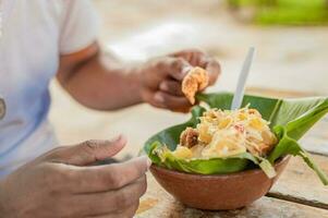 Closeup of person eating vigoron on table. Local person eating a traditional vigoron. The vigoron typical food of Granada, Concept of typical food of Nicaragua photo