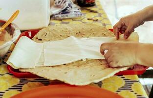 Preparation of Traditional Nicaraguan Quesillo. Person making delicious Nicaraguan cheese. Traditional cheese with pickled onion, Hands preparing the traditional Nicaraguan Quesillo photo