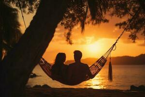 silueta de joven Pareja relajante en hamaca en tropical playa a puesta de sol ai generado foto