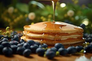 Delicious pancakes, with fresh blueberries and maple syrup flows from a stack of pancake photo