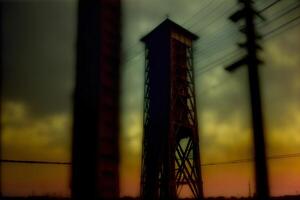 A Tall Tower Sitting Next To Power Lines Under A Cloudy Sky. AI Generated photo