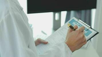 Health care researchers working in life science laboratory. Young female research scientist and senior male supervisor preparing and analyzing microscope slides in research lab. video