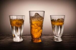 Tres lentes lleno con líquido y hielo en un mesa. ai generado foto