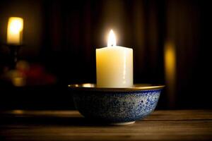 A Lit Candle In A Bowl On A Table. photo