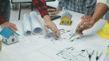 équipe de Multi-éthnique architectes travail sur construction des plans dans réunion chambre. ingénieurs discuter sur projet dans bureau. mature homme d'affaire et femme permanent autour table travail sur plan. video