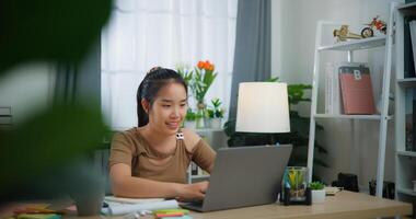 joven asiático mujer trabajando con un ordenador portátil en un escritorio foto