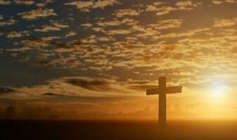 Silhouette of catholic cross at sunset background. photo