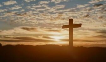 Silhouette of catholic cross at sunset background. photo