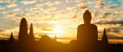 Silhouette of Buddha on golden temple sunset background. Travel attraction in Thailand. photo