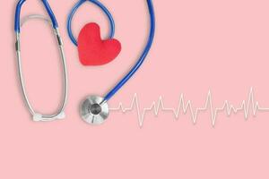 Blue stethoscope medical with red heart and cardiogram on pink background. Idea for health care concept. Copy space for text. photo