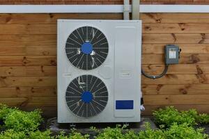 Air conditioner compressor installed outside of the wood house. photo