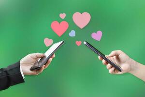 Couple hands holding mobile phone with hearts, Love symbol on blurred background. Valentine's day concept. photo