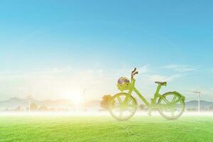 Green bicycle and globe on wind turbine field with blue sky background. Environmentally friendly concept. photo