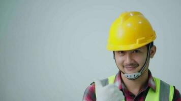 asiatisch jung Ingenieur tragen ein Gelb Sicherheit Brille und Sicherheit Weste. suchen zu das Seite und lächelnd. video