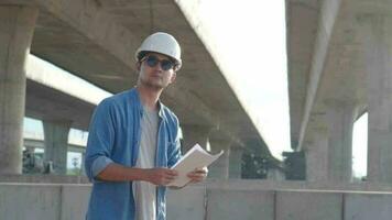ásia Civil engenheiro é inspecionando construção projeto uma estrada via Expressa às construção local. video