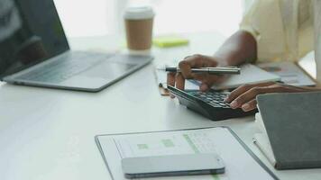 Charming Young asian businesswoman sitting on laptop computer in the office, making report calculating balance Internal Revenue Service checking document. video