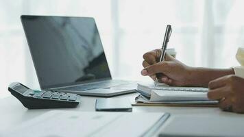 Charming Young asian businesswoman sitting on laptop computer in the office, making report calculating balance Internal Revenue Service checking document. video