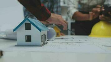 Team of multiethnic architects working on construction plans in meeting room. Engineers discussing on project in office. Mature businessman and woman standing around table working on blueprint. video