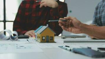 Team of multiethnic architects working on construction plans in meeting room. Engineers discussing on project in office. Mature businessman and woman standing around table working on blueprint. video
