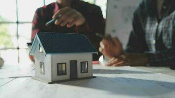 Team of multiethnic architects working on construction plans in meeting room. Engineers discussing on project in office. Mature businessman and woman standing around table working on blueprint. video