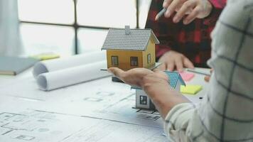 Team of multiethnic architects working on construction plans in meeting room. Engineers discussing on project in office. Mature businessman and woman standing around table working on blueprint. video