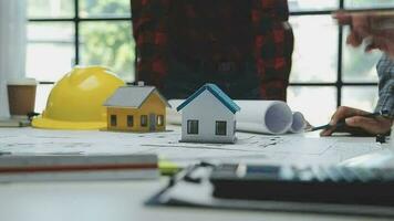 Team of multiethnic architects working on construction plans in meeting room. Engineers discussing on project in office. Mature businessman and woman standing around table working on blueprint. video