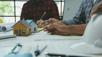 Team of multiethnic architects working on construction plans in meeting room. Engineers discussing on project in office. Mature businessman and woman standing around table working on blueprint. video