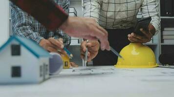 Team of multiethnic architects working on construction plans in meeting room. Engineers discussing on project in office. Mature businessman and woman standing around table working on blueprint. video