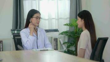 hermosa asiático mujer médico examinando joven mujer en un hospital. video