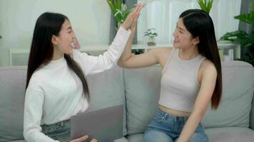 Teamwork happy asian women best friends  laughing while working with laptop at home. video