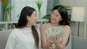 Zusammenarbeit jung asiatisch jung Frauen sind zeigen Dollar und zeigen Daumen hoch. online Businessteam Erfolg . video