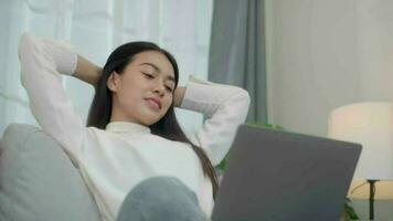 Young beautiful asian woman using laptop sitting Relaxing posture on sofa at  home. video