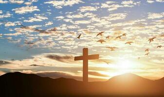 Silhouette of catholic cross at sunset background. photo