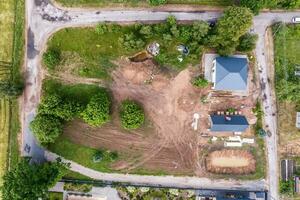 panoramic aerial view of eco village with wooden houses, gravel road, gardens and orchards photo