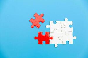 White and red jigsaw puzzle on a blue background. Copy space for text, top view, close up. photo