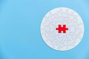 White and red jigsaw puzzle on a blue background. Copy space for text, top view, close up. photo