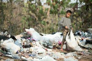los niños pobres recogen basura para la venta debido a la pobreza, el reciclaje de basura, el trabajo infantil, el concepto de pobreza, el día mundial del medio ambiente, foto
