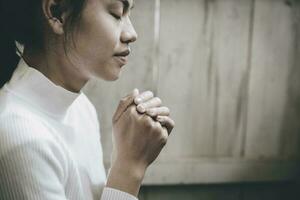 mano niña Orando en el iglesia, manos doblada en oración concepto para fe, espiritualidad y religión. Clásico tono. foto