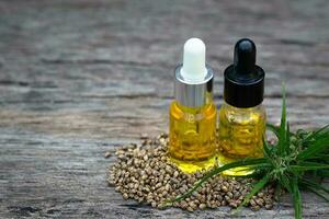 Hemp oil and hemp seeds on a wooden table, Medical marijuana products including cannabis leaf, cbd and hash oil, alternative remedy or medication,medicine concept. photo