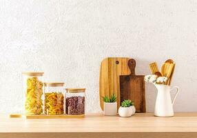 Front view of the wooden countertop of an eco-friendly kitchen with jars for storing bulk products and cutting boards. space for text. photo
