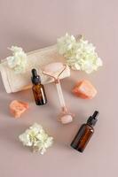 A set of cosmetics in bottles with a pipette, a roller and bath salts on a pastel background. The concept of self-care. spa. Top vertical view. photo