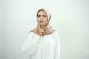 Portrait of thinking young Asian woman looking up and touch chin isolated on over white background photo