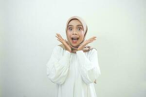 Overjoyed beautiful Asian woman in casual shirt celebrating big luck and success isolated over white background photo