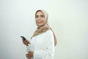 emocionado hermosa asiático musulmán mujer demostración móvil teléfono aislado terminado blanco antecedentes foto