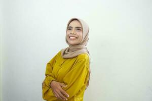 Portrait of a confident smiling Asian Muslim woman wearing hijab standing with arms folded isolated over white background photo