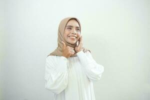 Beautiful smiling Asian woman in white casual showing thumbs up gesture with hand isolated over white background photo